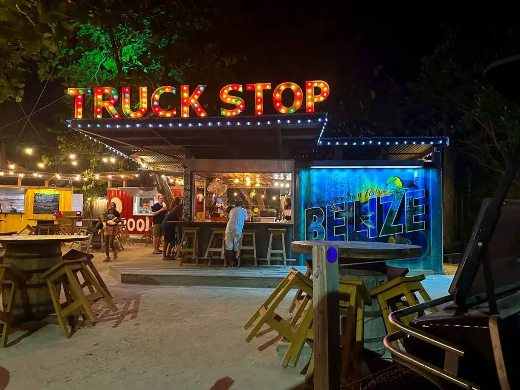 Photo of the Truck Stop restaurant and bar just North of San Pedro, Belize on Ambergris Caye with the words "Truck Stop" lit up on a red neon sign.