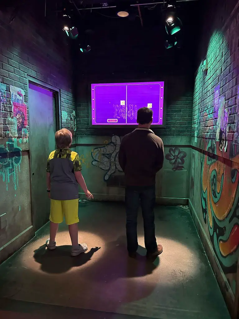 Photo of Luke and his nephew Maverick playing an interactive game at Meow Wolf Denver