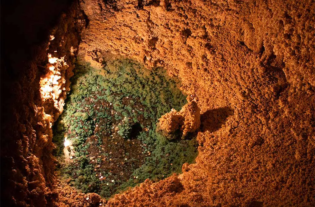 Photo of pond with blue coloring from copper pennies inside the Caverns of Sonora