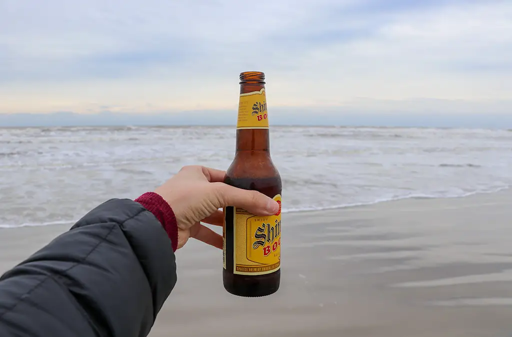 Photo of woman's arm holding a bottle of Shiner Bock beer on the Texas coast for a blog on the Top 5 Things To Do In Texas