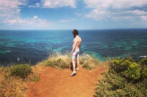 Photo of Luke looking out over the coast from the Great Ocean Road in Victoria, Australia. Adventure Travel