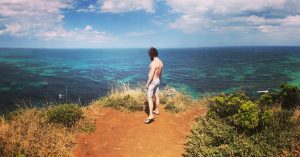 Photo of Luke looking out over the coast from the Great Ocean Road in Victoria, Australia.