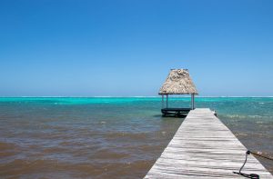 Photo of private dock in the Caribbean Sea with a palapa at the end to represent sustainable travel.