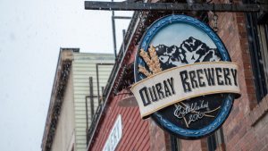 Photo of the Ouray Brewery sign with snow falling around it.