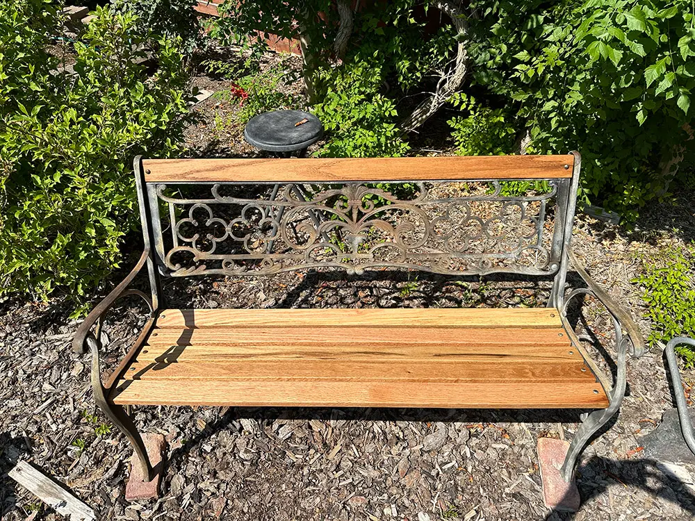 Photo of a renovated antique garden bench with new, danish oil finished red oak slats for Applied Worldwide Lifestyle blog titled "Renovating an Antique Garden Bench with Red Oak"