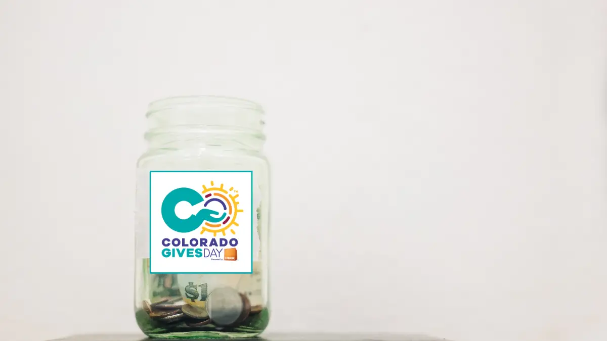 Photo of a donation jar off center with the Colorado Gives logo on it.