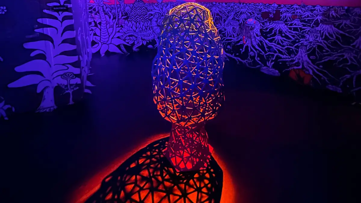 Featured Image for Applied Worldwide Lifestyle Blog titled "Visiting Meow Wolf Denver with a Ten Year Old" showing a morel mushroom sculpture with bring red and purple lights shining through it