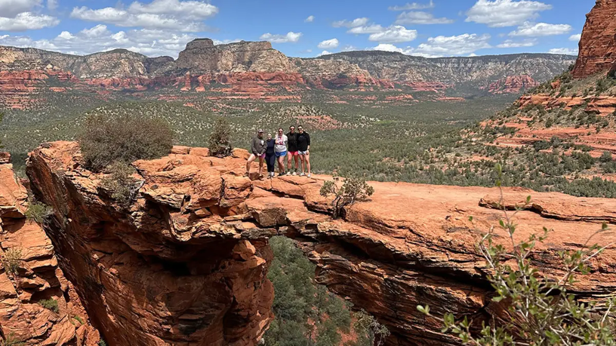 Photo of five women on a group trip in scenic Sedona standing on the "Devil's Bridge" for Applied Worldwide lifestyle blog titled "Group Travel? How To Plan A Vacation That'll Suit Everyone"