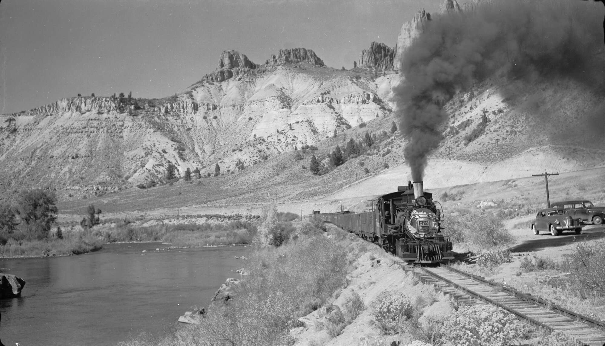 Photo of a steam engine train running alongside the Gunnison River near Sapinero in 1951