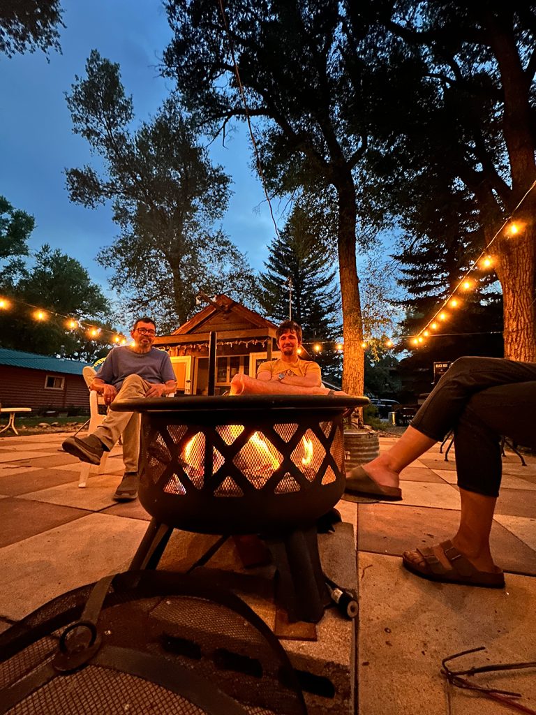 Photo of family sitting around the first at Island Acres Resort in Gunnison, CO for Applied Worldwide blog "5 Types of Family Vacation Everyone Should Love"