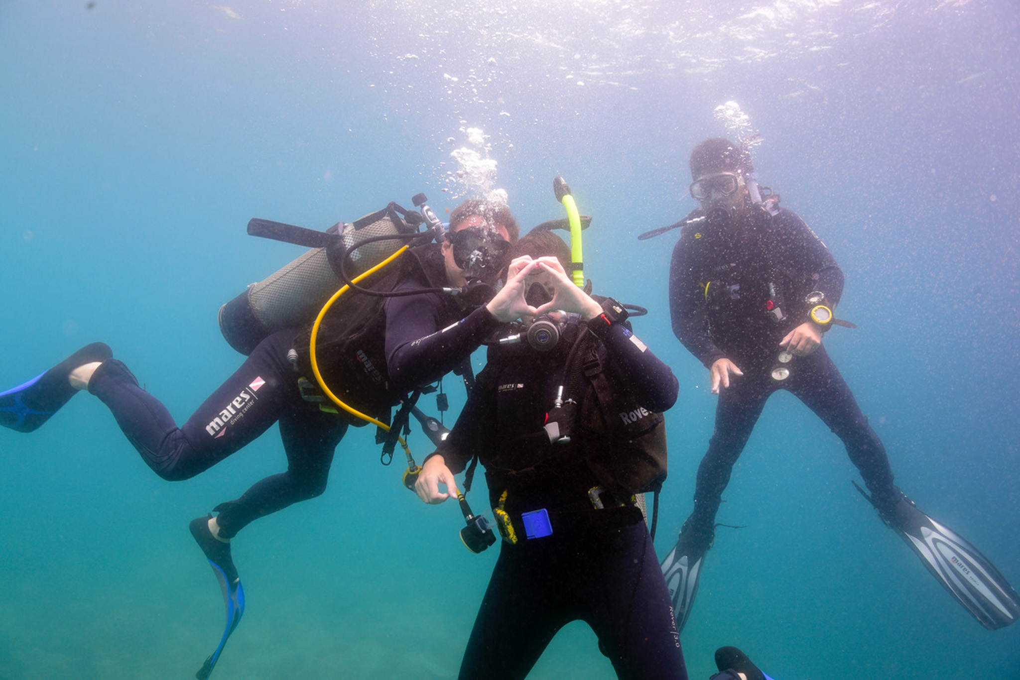 Photo of Stephanie and Luke scuba diving in Vietnam and using their hands to make a heart underwater for Applied Worldwide Lifestyle blog "When The Weather Is Perfect: 3 Simple Ideas For Maximum Enjoyment"