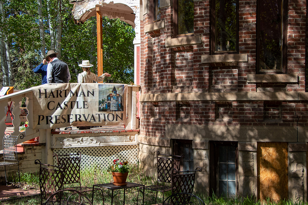 Photo of Hartman Castle Preservation Sign hanging on the porch at the Hartman Castle Art Fair for Applied Worldwide blog "Hartman Castle Welcome Community for First Time in Century"