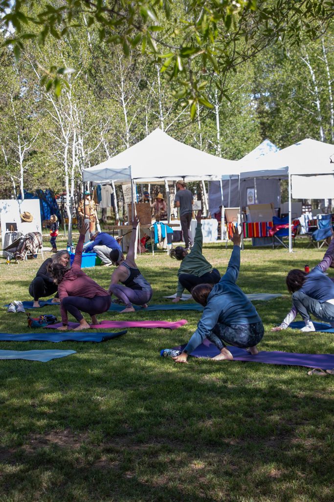 Group of community members in the midst of a morning yoga flow from Dragon yoga for Applied Worldwide blog "Hartman Castle Welcome Community for First Time in Century"