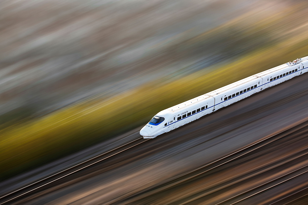 Photo of a Shinkansen bullet train in Japan with focus on the train in motion while the background is blurred to show speed for Applied Worldwide blog "Top 5 Unforgettable Travel Experiences for Train Lovers"
