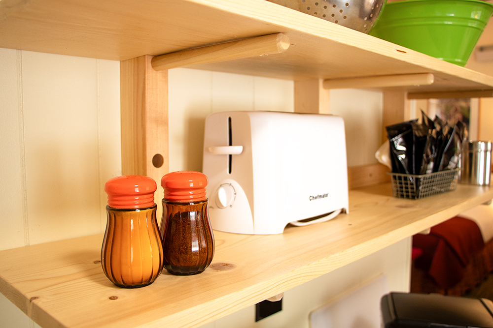 Photo of custom mid-century open wood shelving in the kitchen of a Deluxe Queen Studio at Island Acres Resort Motel