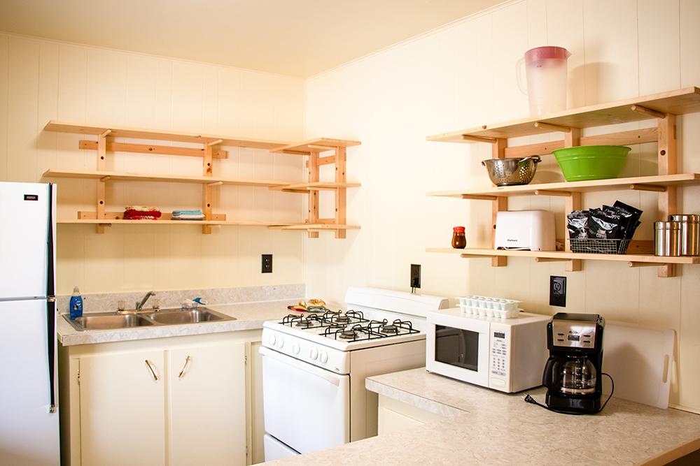 Photo of the kitchen in a Deluxe Queen Studio unit at Island Acres Resort Motel returning wooden handcrafted open shelving.