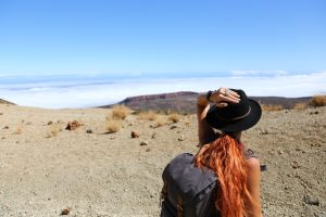 Woman with a backpack looking out over the horizon in the desert for Applied Worldwide blog "Details You Don't Want To Forget When Planning Your Trip"