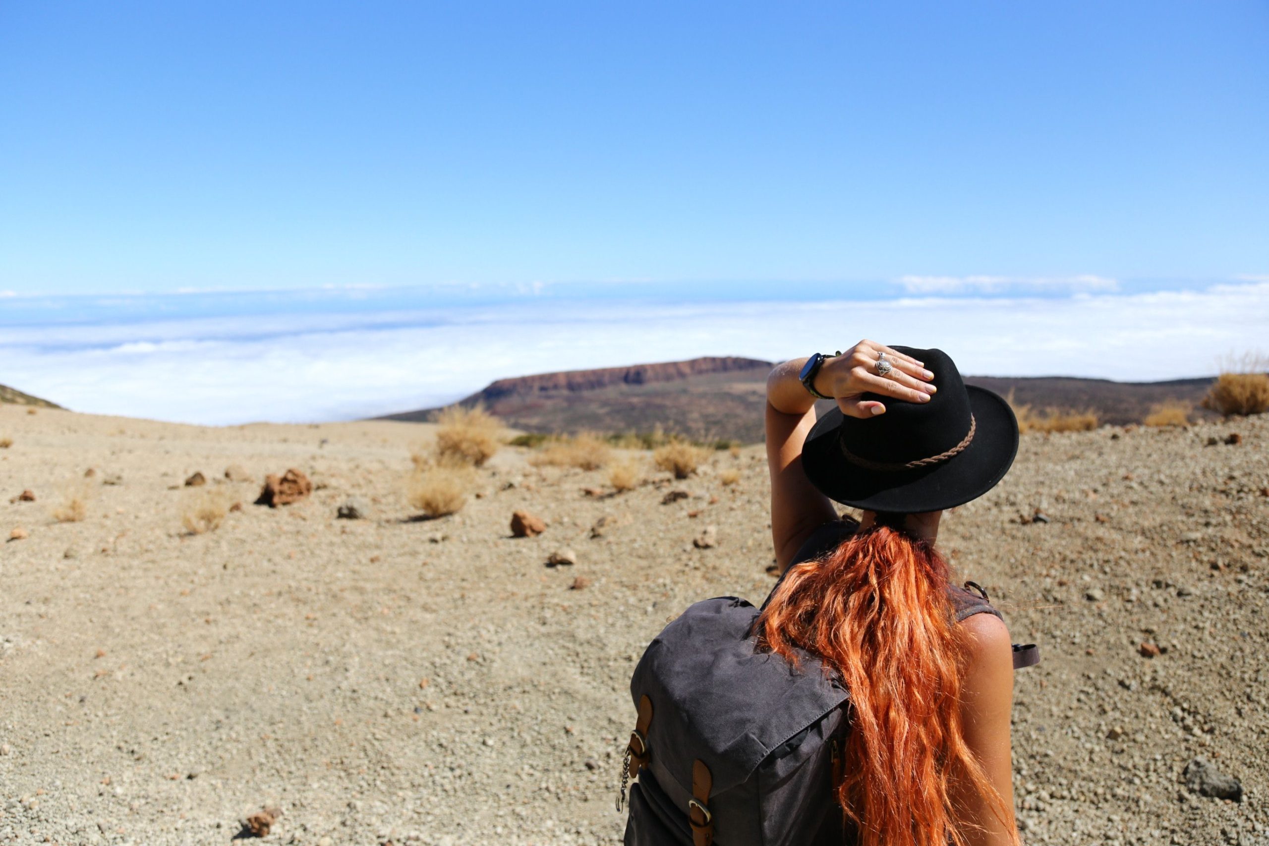 Woman with a backpack looking out over the horizon in the desert for Applied Worldwide blog "Details You Don't Want To Forget When Planning Your Trip"